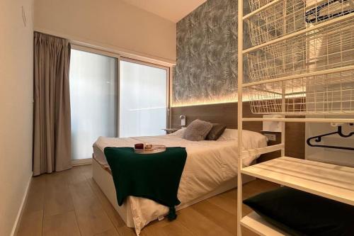 a bedroom with a bed with a green blanket on it at Hola Pamplona! in Pamplona