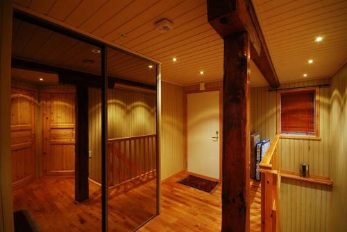 a hallway of a home with wooden floors and a glass door at Rorbu Suite with sauna and steam. Henningsvær in Henningsvær