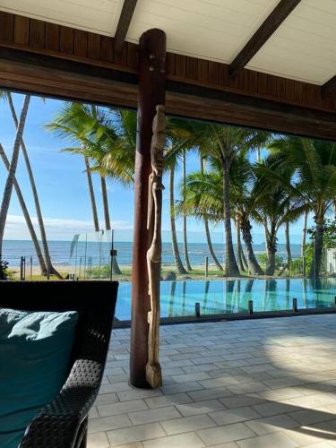 a view of a resort with a pool and palm trees at BALA Beach House on ABSOLUTE Beachfront in Newell Beach