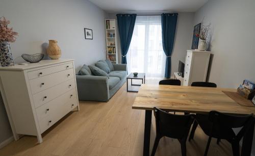 salon ze stołem i kanapą w obiekcie Blue Rooster Apartment. Cozy and quiet place to stay w Warszawie