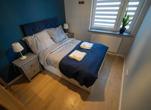 sypialnia z łóżkiem z dwoma ręcznikami w obiekcie Blue Rooster Apartment. Cozy and quiet place to stay w Warszawie