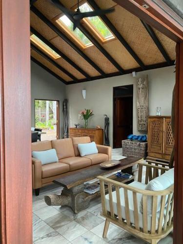 a living room with a couch and a table at BALA Beach House on ABSOLUTE Beachfront in Newell Beach