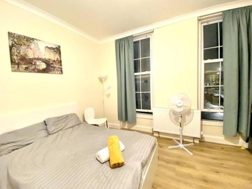a bedroom with a bed and a fan and windows at Private Studio in Central London moments from Oxford St in London