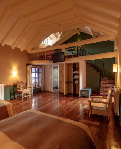 a large room with a bed and a staircase at Tambo del Arriero Hotel Boutique in Cusco