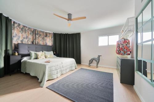 1 dormitorio con 1 cama y ventilador de techo en La Macarena Parque Tecnológico en Málaga