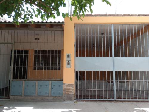 dois conjuntos de portas de garagem em frente a um edifício em Departamento West em Las Heras