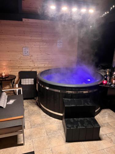 a large hot tub in a room with smoke at Kenzo Chalet in Porumbacu de Sus