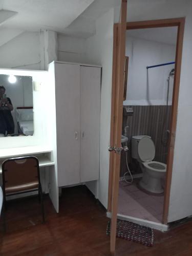 a bathroom with a toilet and a sink and a mirror at Czar's Place in Siquijor