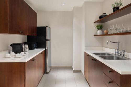 a kitchen with wooden cabinets and a stainless steel refrigerator at Sheraton Puerto Rico Resort & Casino in San Juan
