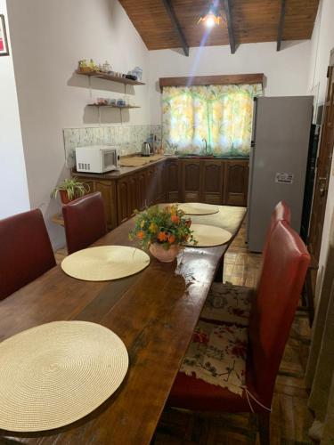 kuchnia z drewnianym stołem z krzesłami i lodówką w obiekcie Terra bela w mieście Puerto Iguazú