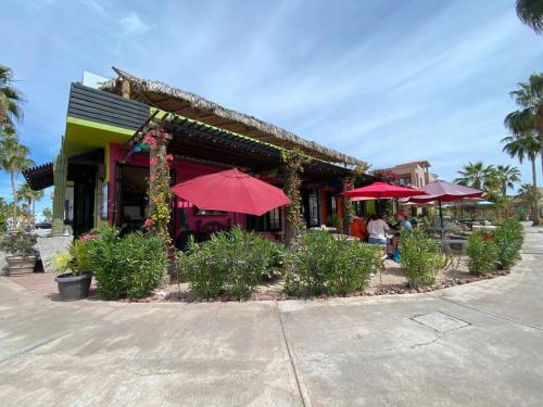 a restaurant with red umbrellas in front of it at Wonderful 3 Bedrooms & 3 Bathrooms Home in Loreto