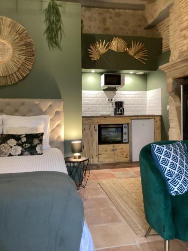 a bedroom with a bed and a couch and a kitchen at Le Mas Réolais in Saint-Sève