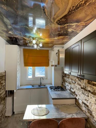 a kitchen with a ceiling with a painting on it at Central Apartment in Constanţa