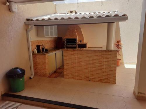 a kitchen with a brick wall with a roof over it at Casa de praia em Mar Grande-Ilha Itaparica in Vera Cruz de Itaparica