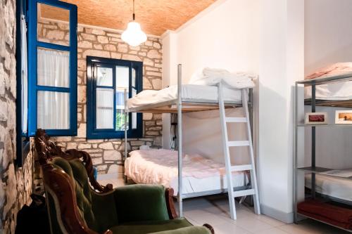 Pokój z 2 łóżkami piętrowymi i krzesłem w obiekcie Himara Hostel w mieście Himara