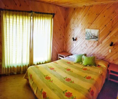 1 dormitorio con 1 cama en una habitación de madera en Cabañas Colliguay, Quilpué., en Quilpué