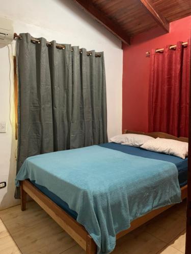 a bedroom with a bed and a curtain at Terra bela in Puerto Iguazú