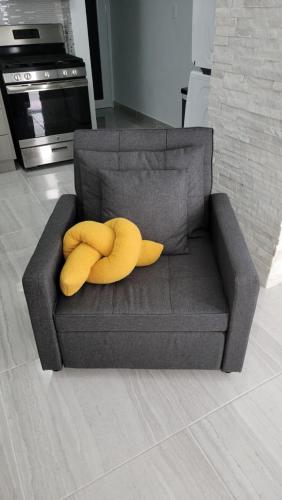 a yellow stuffed banana sitting on a gray couch at The Yellow Spot in Fajardo