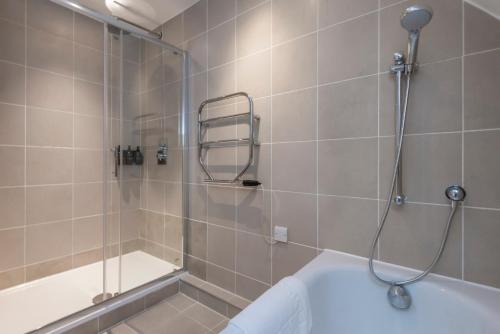 La salle de bains est pourvue d'une douche et d'une baignoire. dans l'établissement The Balham Loft - NEW Gorgeously appointed with FREE parking and tube close by, à Londres