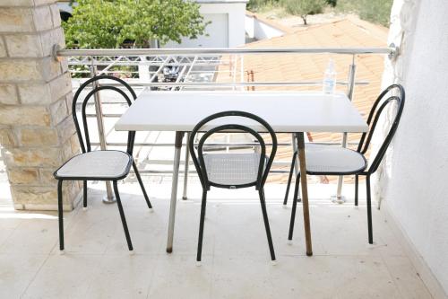 einen weißen Tisch und zwei Stühle auf dem Balkon in der Unterkunft Apartments Swiss in Vodice