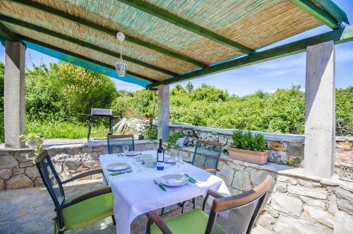 a table and chairs under a pergola at House Vinko in Račišće