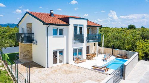 a villa with a swimming pool and a house at Apartments Fortis in Drage