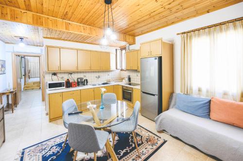 a kitchen and living room with a table and a couch at Small Villa Gerani in Agios Vlasios