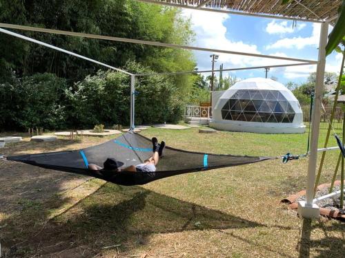 a person laying on a hammock in a park at Dome in the Heart of Boquete. in Boquete