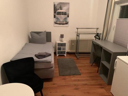 ein kleines Schlafzimmer mit einem Bett und einem Schreibtisch in der Unterkunft Ferienwohnung/Monteurwohnung in Salzgitter