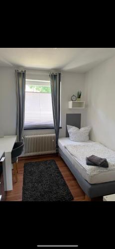 Schlafzimmer mit einem Bett, einem Fenster und einem Schreibtisch in der Unterkunft Ferienwohnung/Monteurwohnung in Salzgitter