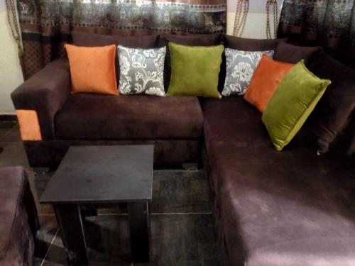 un divano in pelle marrone con cuscini colorati di CTD Global Integrated a Jos
