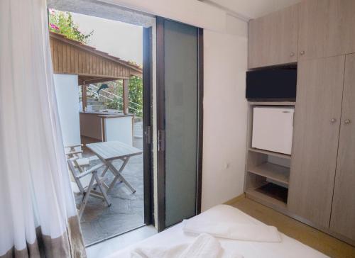 a bedroom with a sliding glass door leading to a patio at Marina Hotel in Agios Kirykos