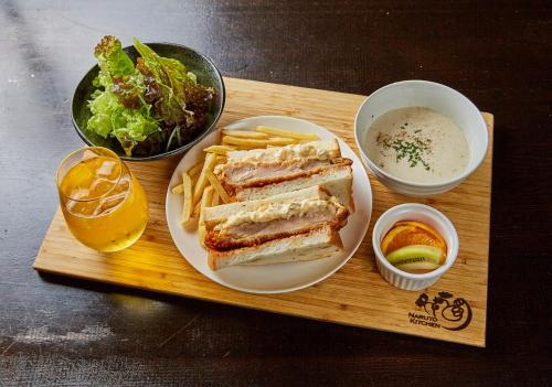 a wooden tray with a sandwich and french fries and a drink at APA Hotel Chiba Yachiyo Midorigaoka in Yachiyo