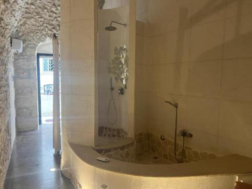 a bathroom with a tub with a shower in it at Maison Carolina in Vieste