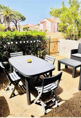 een picknicktafel en stoelen op een patio bij Résidence Antigua - Studio pour 4 Personnes 984 in Le Barcarès