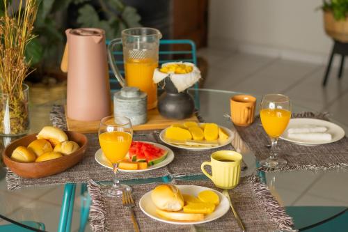 een tafel met fruitschalen en glazen sinaasappelsap bij Refúgio Urbano in Campina Grande