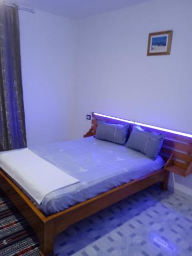 Ce lit se trouve dans un dortoir doté d'un matelas bleu. dans l'établissement l'olivier, à Aghir