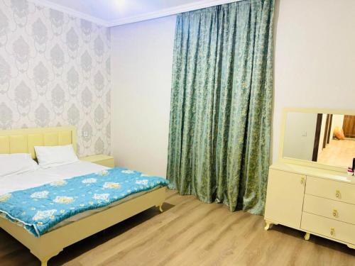 a bedroom with a bed and a dresser and a mirror at Key Explore Hostel Hotel in Baku