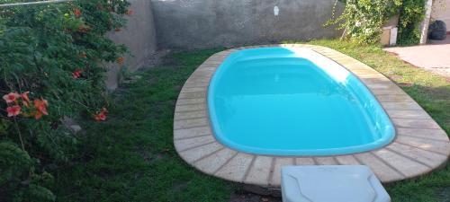una piscina azul en la hierba con un taburete en Hause la rioja en La Rioja