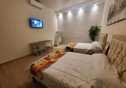 Habitación de hotel con 2 camas y TV en El dorado loft con piscina en Cuatrociénegas de Carranza