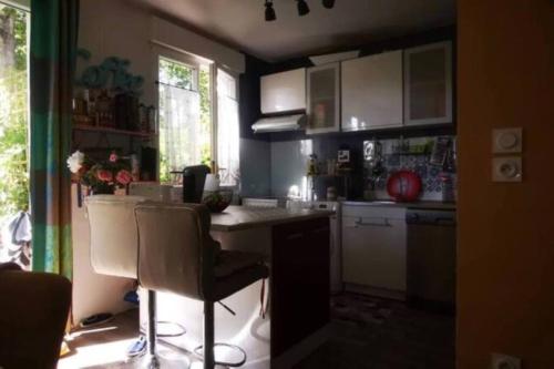 a kitchen with a counter and some chairs in it at Lovely room,Rambouillet in Rambouillet