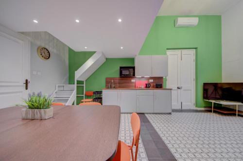a kitchen with a wooden table and green walls at Casa Marie Studio Maisonette in Cospicua