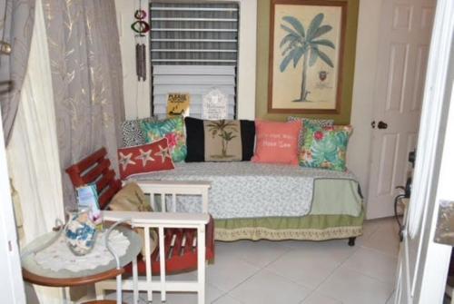 Dormitorio pequeño con cama con almohadas coloridas en Aileen Palm Cove Ja en Ocho Rios