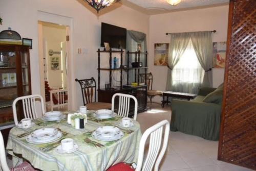 Aileen Palm Cove Ja في أوتشو ريوس: غرفة معيشة مع طاولة مع كراسي وأريكة