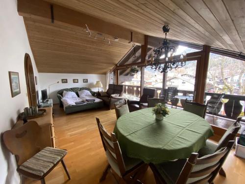 a dining room and living room with a green table at Ferienwohnung Partenkirchen in Garmisch-Partenkirchen