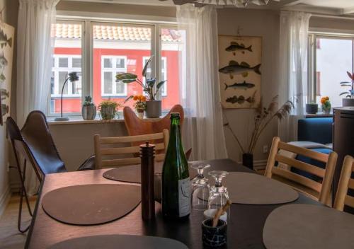 a dining room table with a bottle of wine on it at Nyrenoveret charmerende byhus in Fåborg