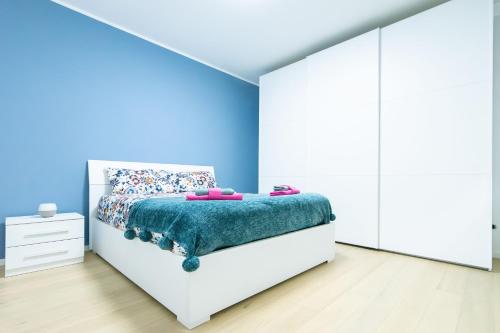 ein Schlafzimmer mit einem Bett mit einer blauen Wand in der Unterkunft A Casa di Emma by SMART-HOME in Genua
