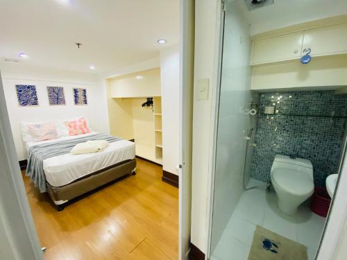 a small bedroom with a bed and a shower at Cebu City Huge Lofts by P&J in Cebu City