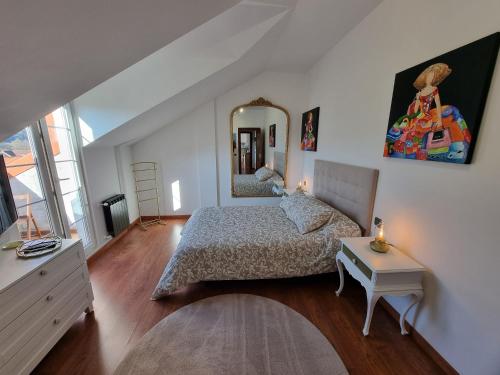 1 dormitorio con cama y espejo en la pared en Romántico apartamento con terraza y piscina, en Villabáñez