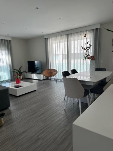 a living room with a table and chairs and a television at Raphael Funchal Views Apartment in Funchal